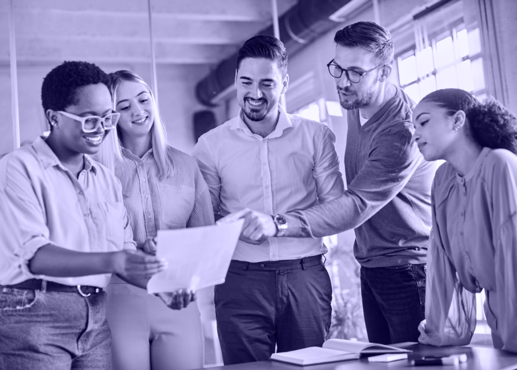 Photo of group of people in an office looking at a document.